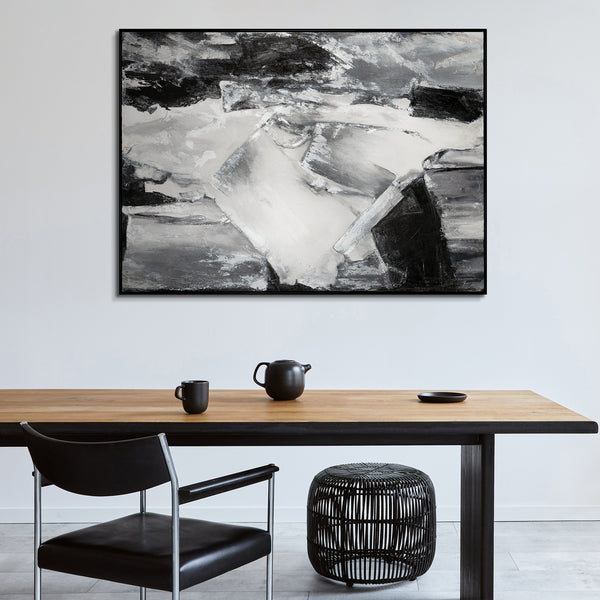 Elegant interior design with a dramatic black and white abstract artwork providing a focal point above a simple yet chic dining setup