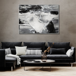 Contemporary living room decor with a large black and white abstract painting over a plush dark sofa, creating a chic and artistic atmosphere