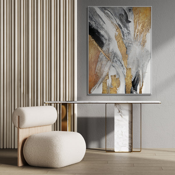 Elegant living room decor featuring a framed abstract painting with golden accents, complementing a marble and gold table and textured armchair