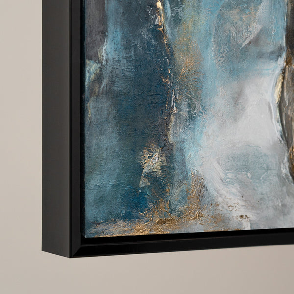 Close-up view of a modern abstract painting featuring rich blue and gold textures on a canvas, elegantly framed in black. Highlighting the detailed brushwork and color blending techniques