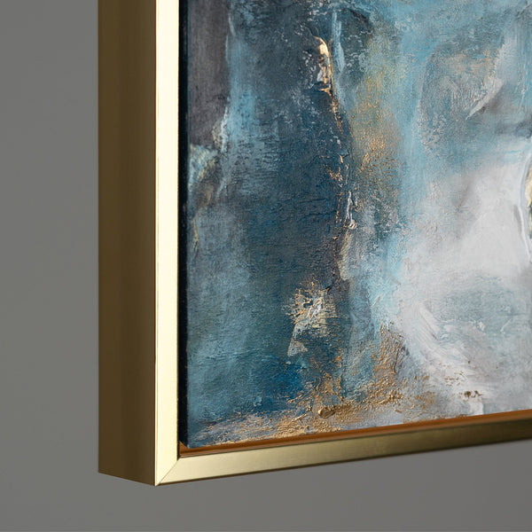 Detail of a contemporary abstract painting framed in gold, showcasing vibrant blue hues blended with metallic gold textures, emphasizing the luxury and richness of the artwork