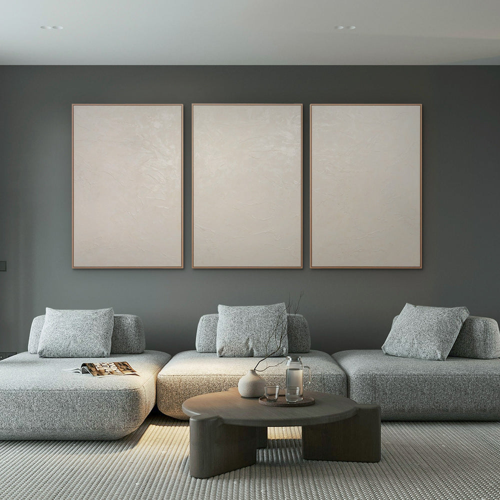 Wandbilder Wohnzimmer beige – Minimalistisches Triptychon in Weiß und Beige über grauem Design-Sofa